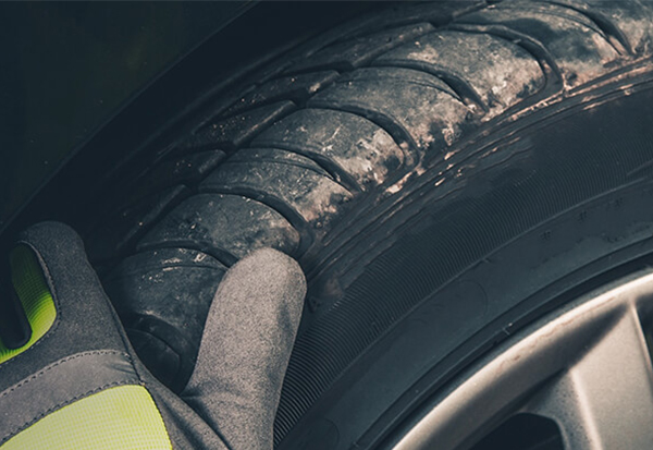 gloved hand working on tire