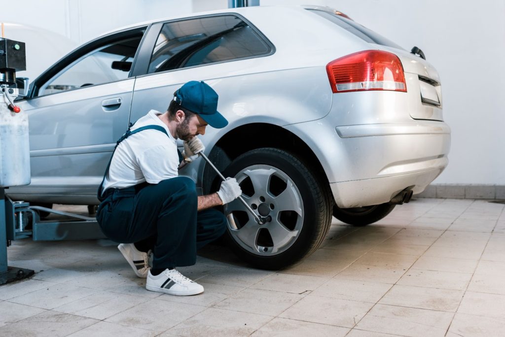 Mechanic changing car tire in auto repair shop