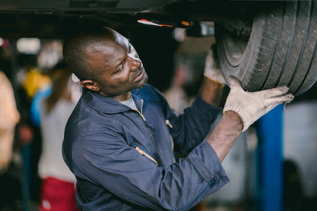 auto mechanic performing a tire rotation service