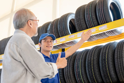auto mechanic showing a customer a variety of tire types