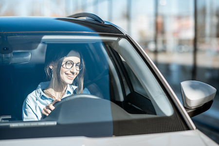 woman smiling while she drives her car