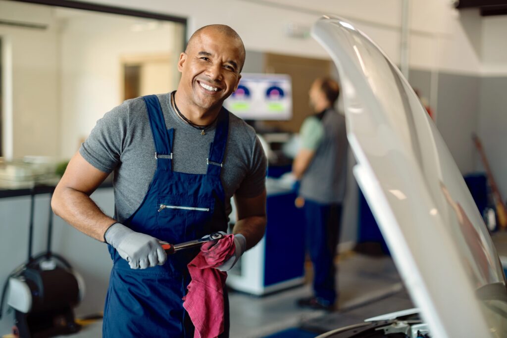 happy-black-auto-mechanic-working-at-car-workshop